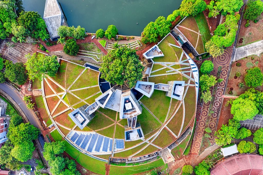 Drone shot of circular architectural design amidst lush greenery in Jawa Barat, Indonesia.