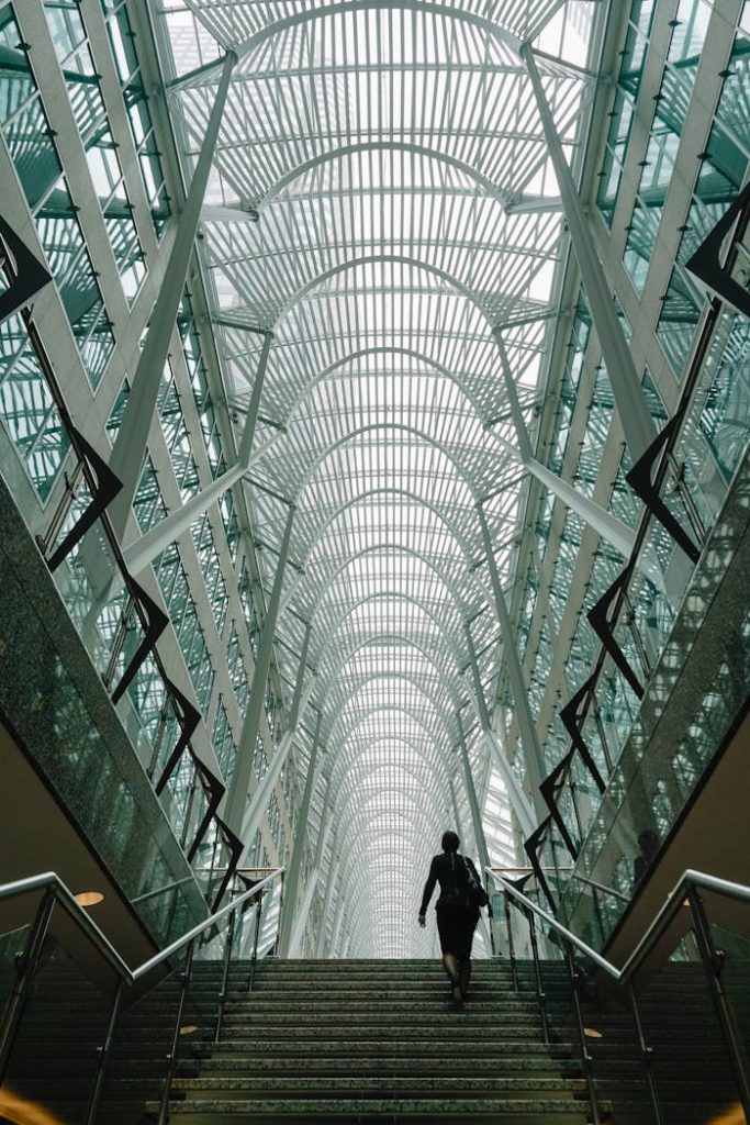 Stunning vertical shot of a modern atrium with a person ascending the staircase in Torontos iconic Brookfield Place.